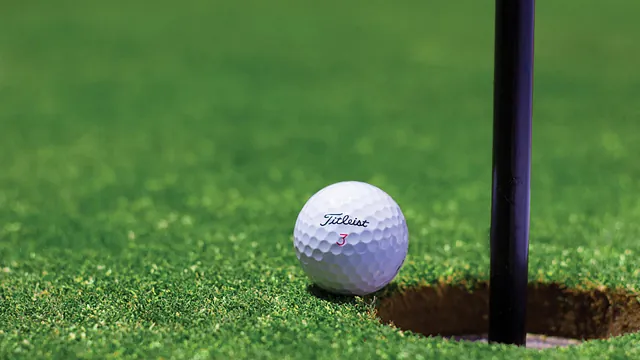 A golf ball near a hole